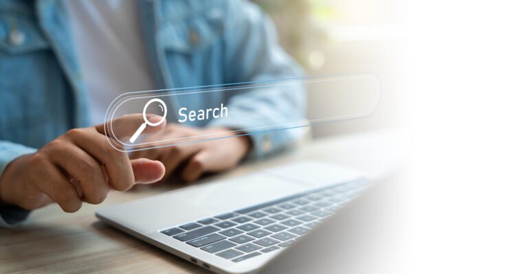 Close-up of a person touching a virtual search bar on a laptop screen, representing website SEO and online search optimization